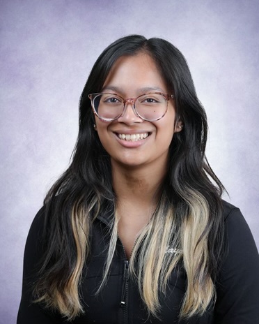 Image of Maya. She has black hair and wears glasses.